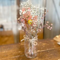 a vase filled with baby's breath flowers on top of a wooden table