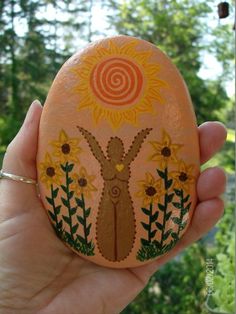 someone is holding an easter egg decorated with sunflowers