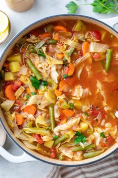 a pot filled with soup and vegetables on top of a table