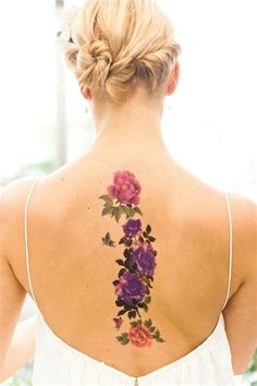 the back of a woman's neck with flowers painted on her upper and lower part