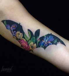 a bat with flowers and leaves on it's arm