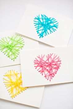 four handmade cards with different colored yarn hearts on the front and back of them