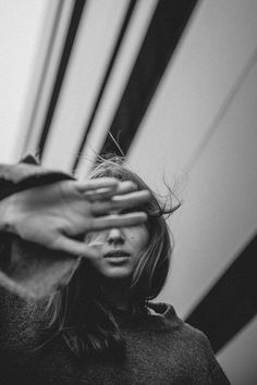 a black and white photo of a woman covering her eyes