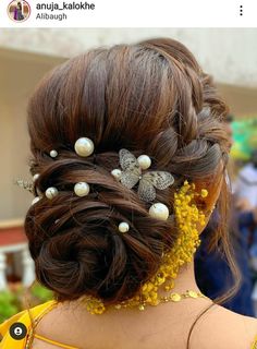 the back of a woman's head with hair combs and pearls in her hair