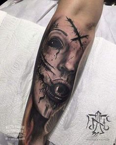 a man's arm with a wolf and cross tattoo on the left side of his arm