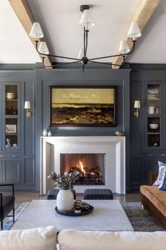 a living room filled with furniture and a fire place under a painting on the wall