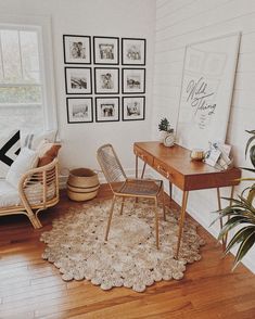 a living room with pictures on the wall and a rug in front of a table