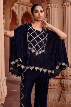 Navy blue cape with floral aari embroidery and cutwork hem. Paired with embroidered flared pant.
Component: 2
Pattern: Embroidered
Type Of Work: Aari
Neckline: Round
Sleeve Type: Split
Fabric: Velvet
Color: Blue
Other Details: 
Cutwork border
Occasion: Sangeet - Aza Fashions Traditional Festive Cape Sets, Traditional Sharara With Floral Embroidery And Cape Sleeves, Traditional Festive Palazzo Set With Cape, Traditional Palazzo Set With Floral Embroidery And Cape Sleeves, Embroidered Palazzo Set With Cape Sleeves For Eid, Cape Sleeves Palazzo Set With Dupatta, Palazzo Set With Cape Sleeves And Dupatta, Traditional Embroidered Palazzo Set With Cape Sleeves, Eid Dupatta With Cape Sleeves