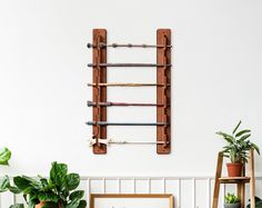 a wooden ladder hanging on the wall next to potted plants