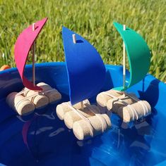 three wooden boats in a blue plastic container