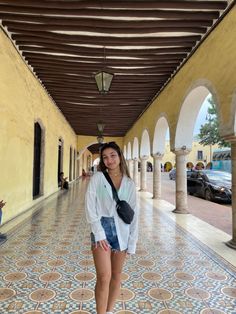 a woman is standing in an archway with her hand on her hip and looking at the camera