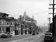 an old photo of cars driving down the street