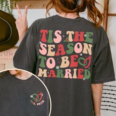 a woman wearing a t - shirt that says tis the season to be married