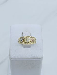 a gold ring sitting on top of a white box