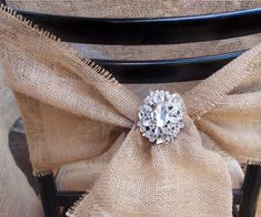 the back of a chair with a bow tie around it's seat and a diamond brooch