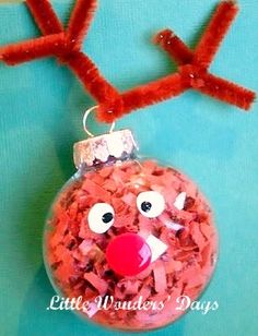 a red nose reindeer ornament hanging on a blue background with fake antlers