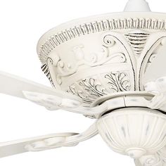 a white ceiling fan with ornate designs on it's blades and light fixture,