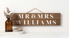 a wooden sign that says mr and mrs williams hanging on a wall next to a bottle