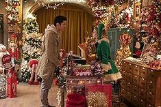 a man and woman looking at christmas decorations in a room full of holiday themed trees