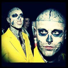 two men with face paint on their faces, one wearing a yellow suit and the other in black