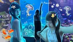 two girls are standing in front of an aquarium with fish and sea creatures on it