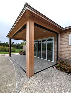 an outdoor covered patio with sliding glass doors and wood posts on the side of it