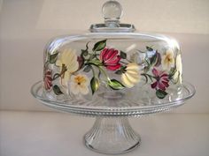 a glass cake plate with flowers painted on it