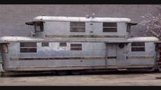 an old bus is parked in front of a building with no doors on it's sides