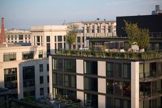 an apartment building with plants growing on the roof