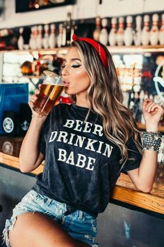 a woman sitting at a bar drinking beer