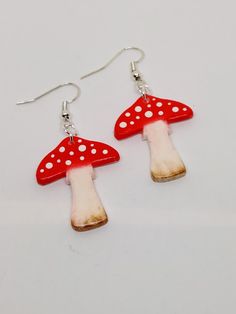 These brightly coloured toadstools look lovely as earrings and will brighten any outfit.  They are hand made from polymer clay, hand painted with pastels and have enamel dots to decorate.  They are glossed for a protective coat.  The ear wires are silver plated. Whimsical Mushroom-shaped Earrings For Gifts, Whimsical White Hand Painted Earrings, Red Mushroom Design Earrings Gift, Unique White Mushroom Design Jewelry, Unique White Jewelry With Mushroom Design, Pink Mushroom Jewelry For Gifts, Unique Adjustable Mushroom Earrings, Cute Handmade Mushroom Earrings, Cute Handmade Mushroom-shaped Earrings