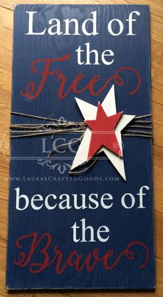 the book land of the free because of the brave is laying on a wooden table