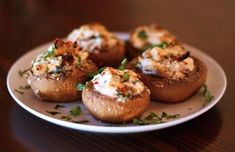 stuffed mushrooms with ricotta on a white plate sitting on a wooden table and the words stuffed mushrooms w / ricotta above it