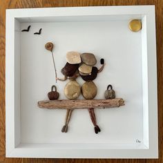 a white frame with some rocks and other items in it on top of a wooden table