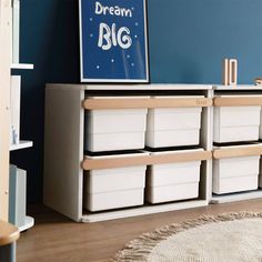 a room with blue walls and white storage bins