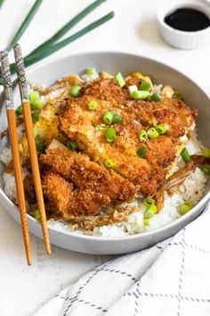 fried chicken and rice in a bowl with chopsticks