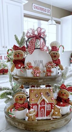 three tiered trays with gingerbread cookies and other holiday decorations on the counter