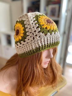 a woman wearing a crocheted hat with sunflowers on it