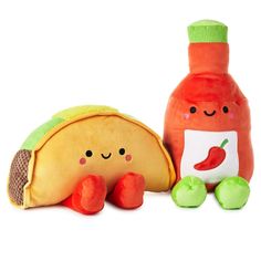 two stuffed animals sitting next to each other near a bottle and tortilla shell