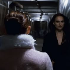 two women standing in an elevator talking to each other