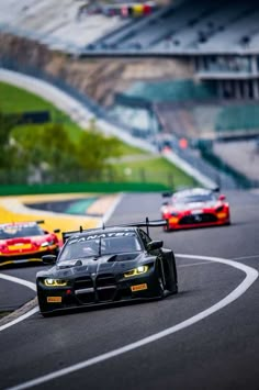 a group of cars driving down a race track