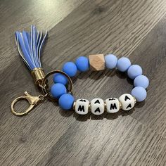 a blue and white beaded bracelet with the word mom spelled out in small letters