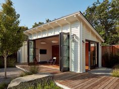 a small white house with a wooden deck