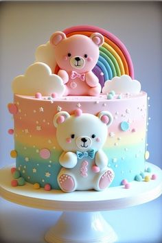 a teddy bear sitting on top of a rainbow colored cake with clouds and stars around it