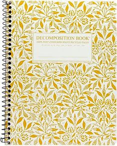 a yellow and white book with an intricate design on the front cover, featuring leaves