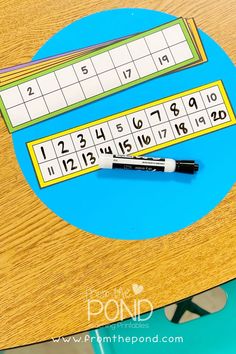 a close up of a wooden table with a pen on top of it and numbers