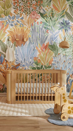 a baby's room with a giraffe toy in front of the wall