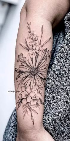 a black and white flower tattoo on the arm