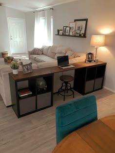 a living room filled with furniture and a laptop computer on top of a wooden table