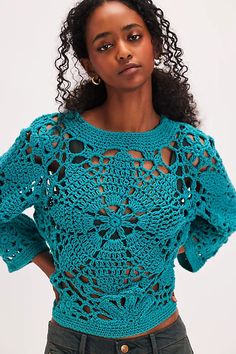 a woman wearing a blue crochet top